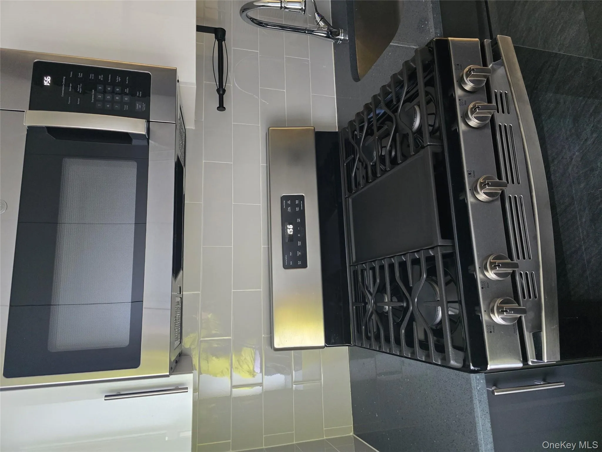 Kitchen view of dark stone counters, decorative backsplash, and stainless steel gas range oven Kitchen view of dark stone counters, decorative backsplash, and stainless steel gas range oven