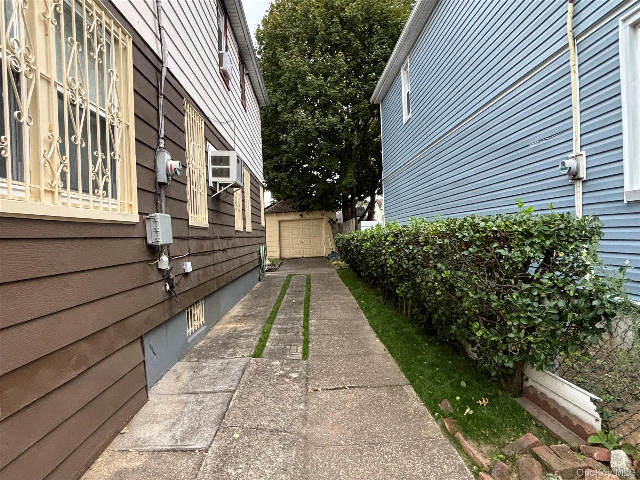 View of side of property with a garage, driveway, and an outbuilding View of side of property with a garage, driveway, and an outbuilding
