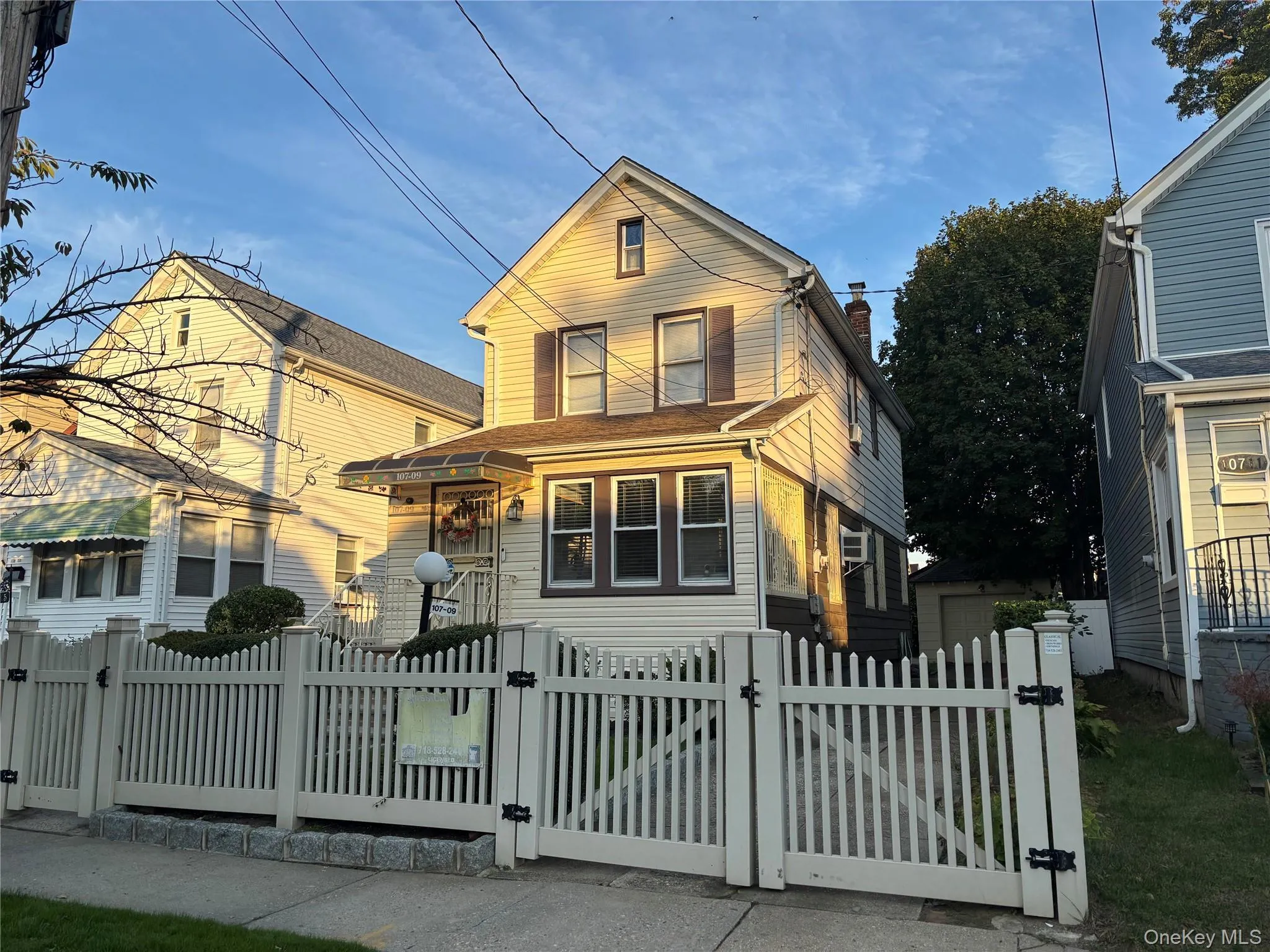 Traditional home with a gate, a fenced front yard, and a chimney Traditional home with a gate, a fenced front yard, and a chimney