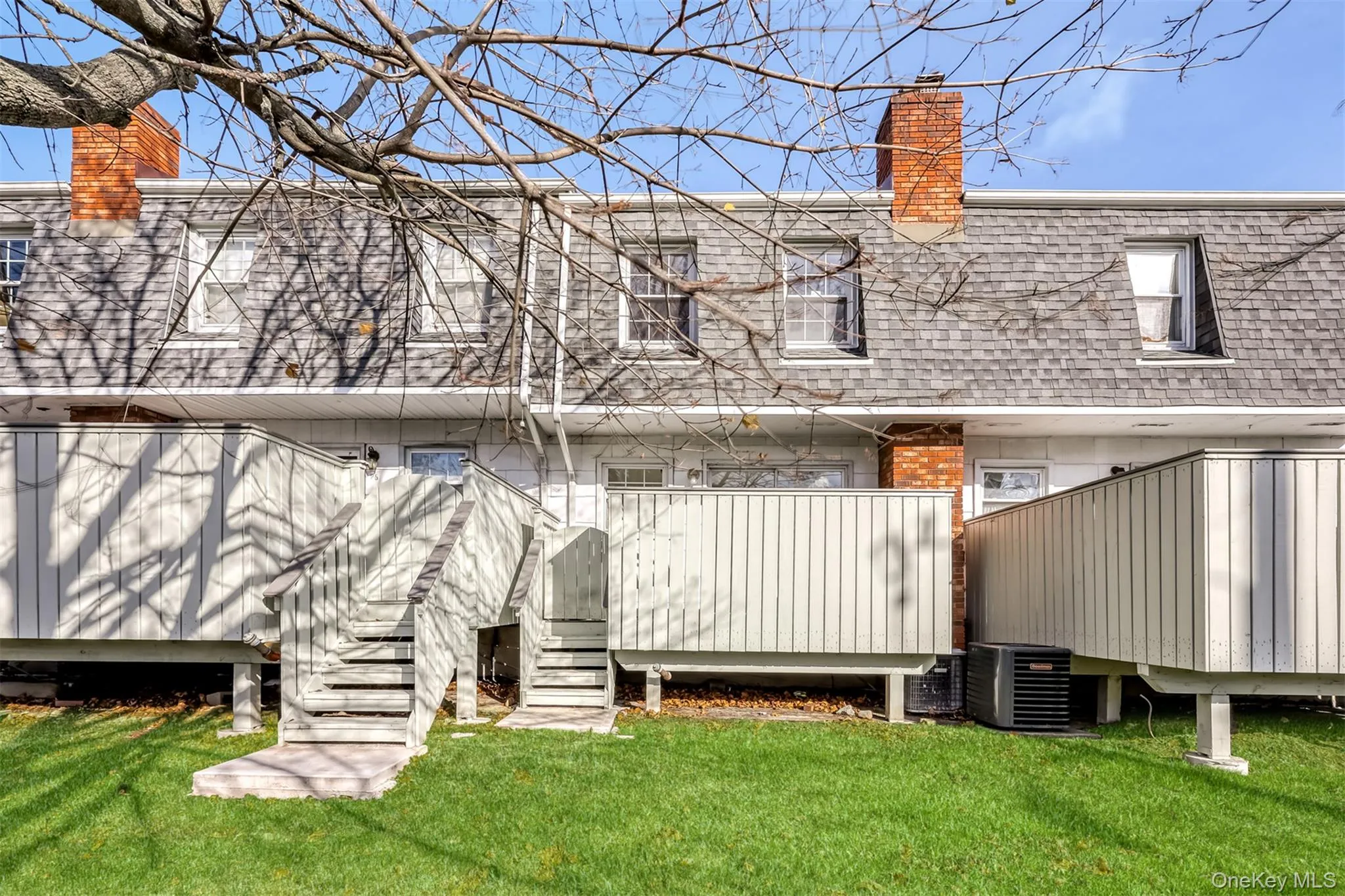 Back of house featuring deck with stairs to shared lawn Back of house featuring deck with stairs to shared lawn