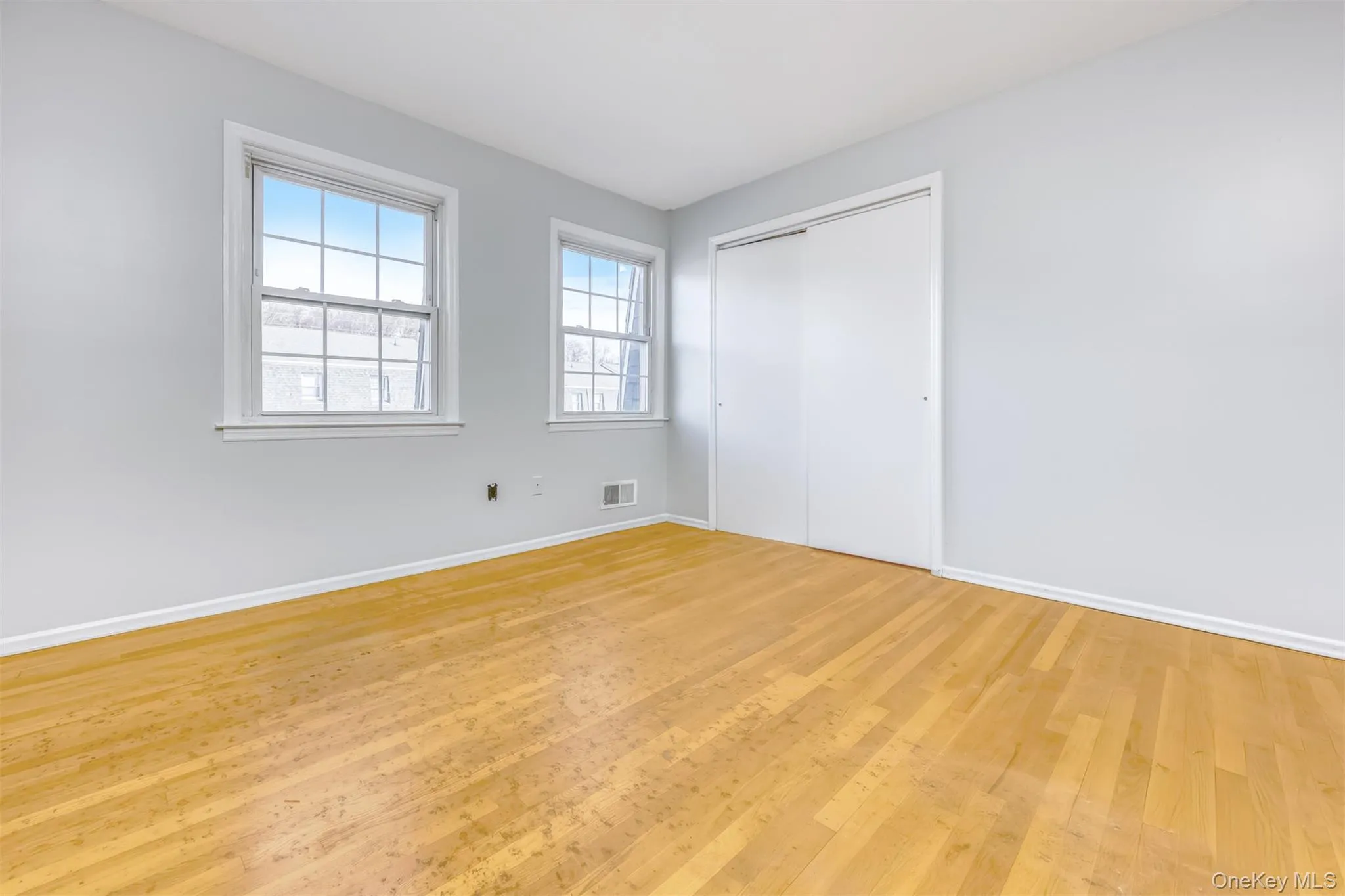 Unfurnished bedroom with hardwood / wood-style flooring and a closet Unfurnished bedroom with hardwood / wood-style flooring and a closet