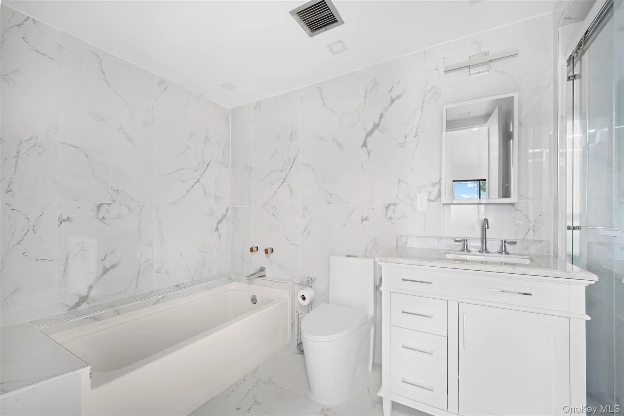 Primary Bathroom featuring vanity, tile walls, stall Shower and tub Primary Bathroom featuring vanity, tile walls, stall Shower and tub