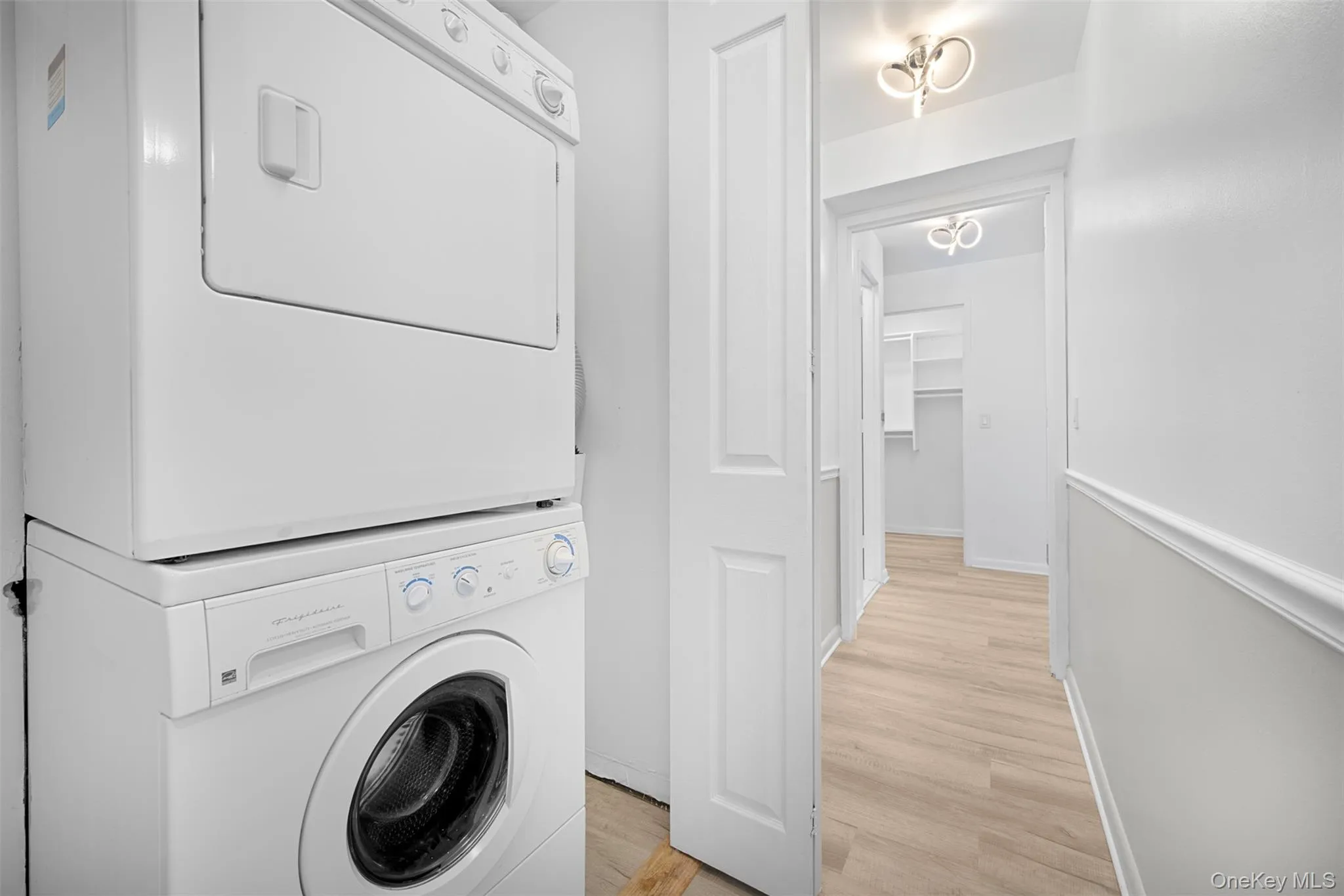 Laundry room featuring light wood-type flooring and washer and dryer Laundry room featuring light wood-type flooring and washer and dryer