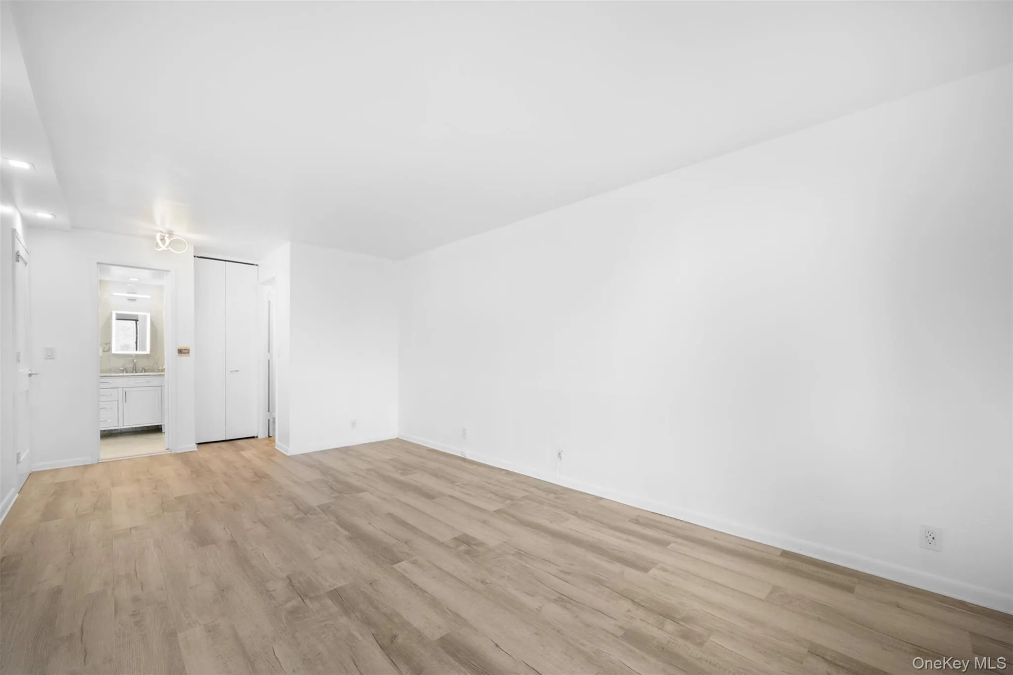 Primary Bedroom closet, ensuite bath, and recessed lighting Primary Bedroom closet, ensuite bath, and recessed lighting