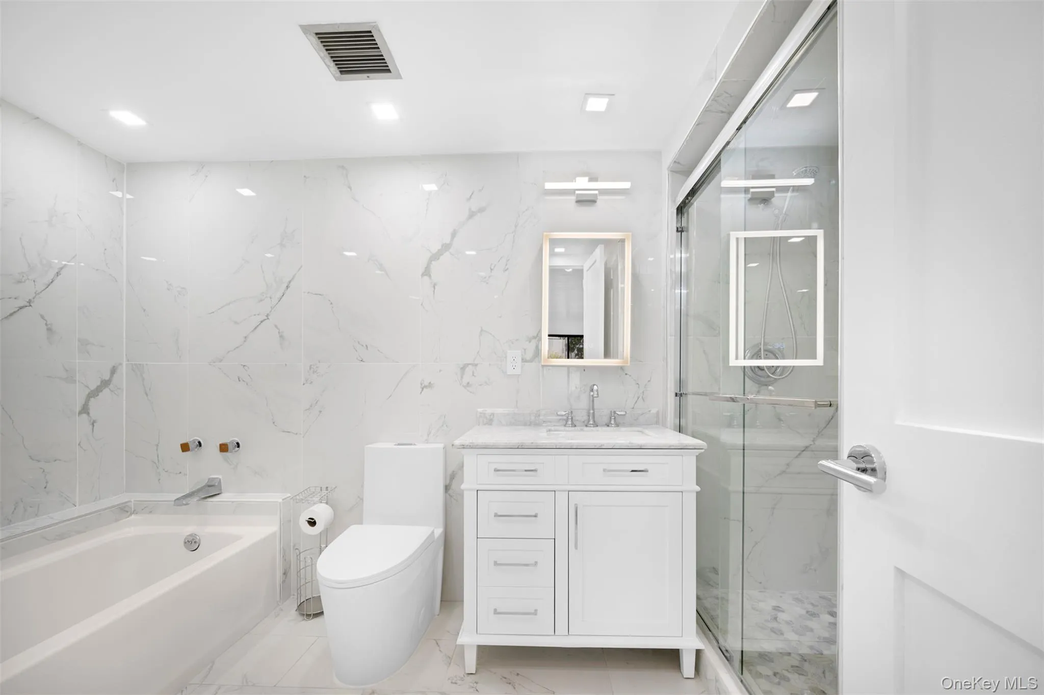 Primary Bathroom with vanity, a marble stall shower, a bath, tile walls, and stone wall Primary Bathroom with vanity, a marble stall shower, a bath, tile walls, and stone wall