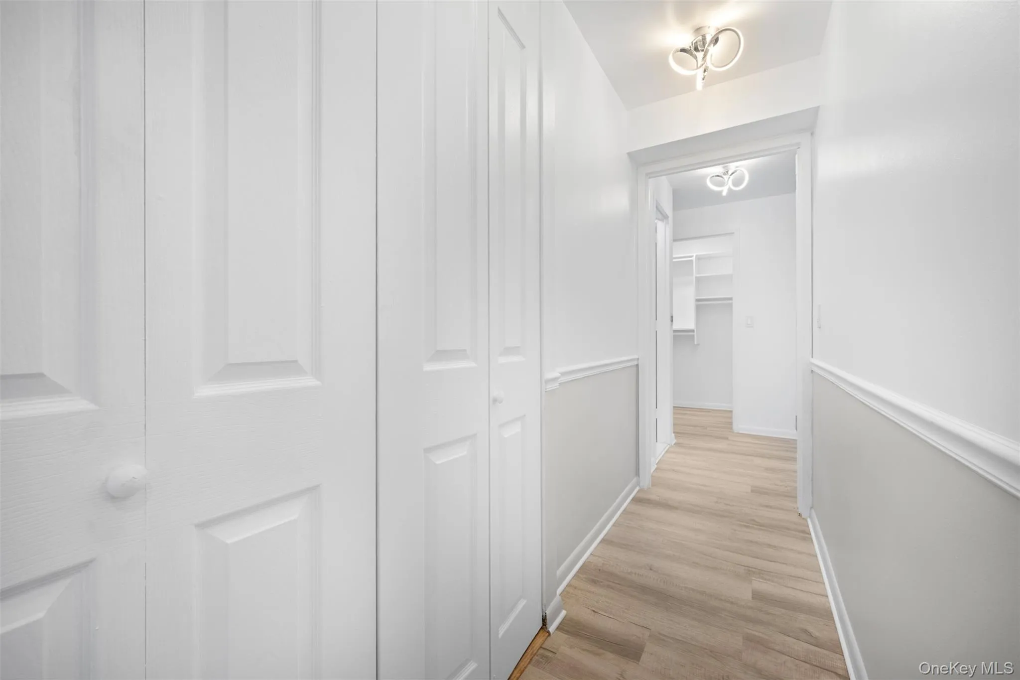 Hallway featuring light wood-style floors Hallway featuring light wood-style floors