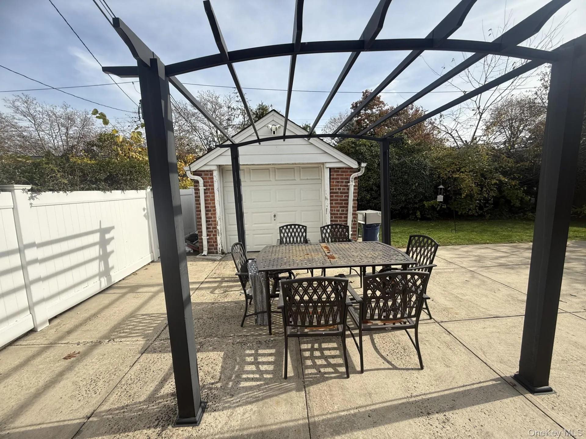 View of patio with outdoor dining area, an outbuilding, a pergola, and a garage View of patio with outdoor dining area, an outbuilding, a pergola, and a garage