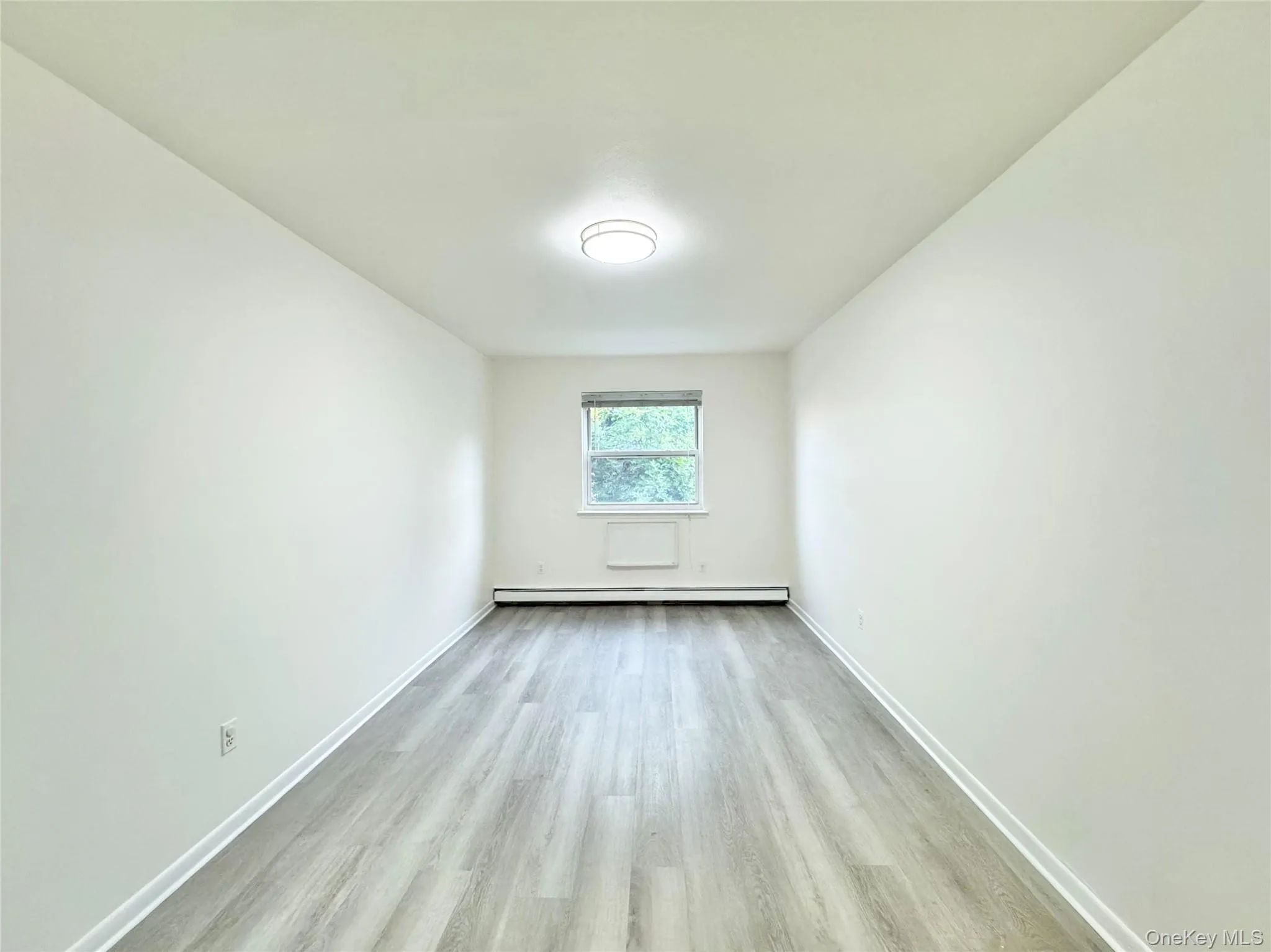 Spare room with light wood-type flooring and baseboard heating Spare room with light wood-type flooring and baseboard heating