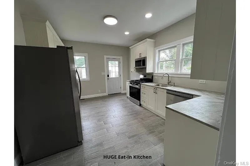 Kitchen with appliances with stainless steel finishes, white cabinets, light wood-style floors, light countertops, and recessed lighting Kitchen with appliances with stainless steel finishes, white cabinets, light wood-style floors, light countertops, and recessed lighting