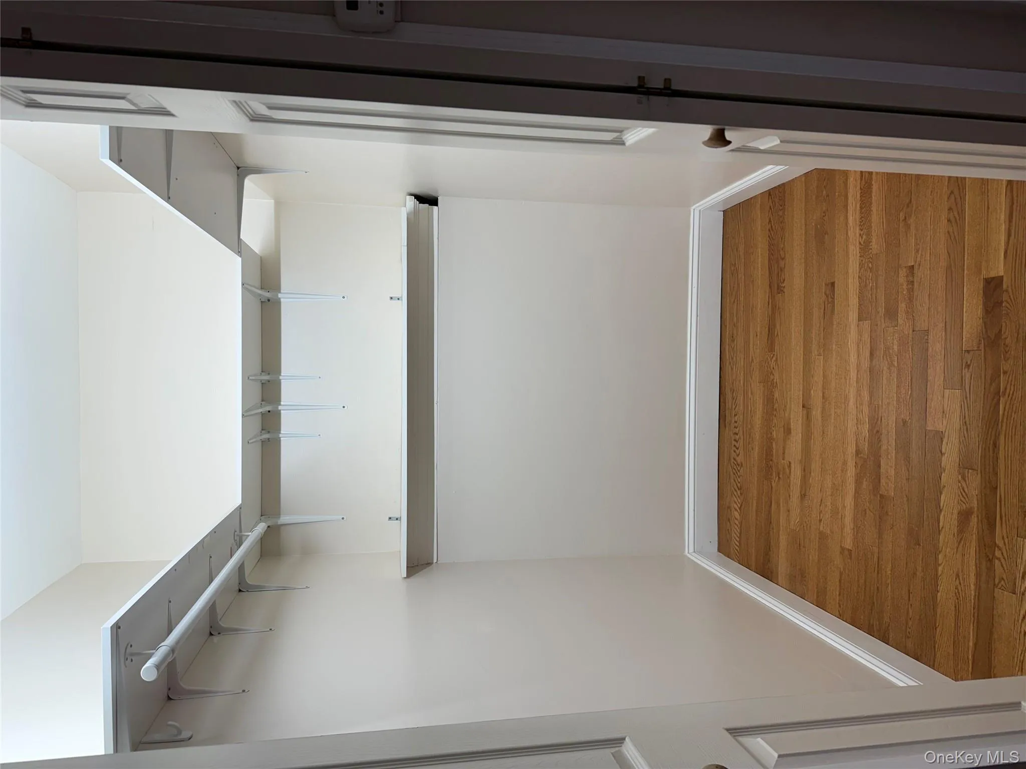 Spacious closet with light wood-type flooring Spacious closet with light wood-type flooring