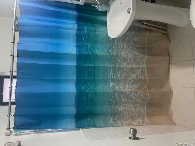 Full bath featuring a shower with curtain and tile patterned floors Full bath featuring a shower with curtain and tile patterned floors