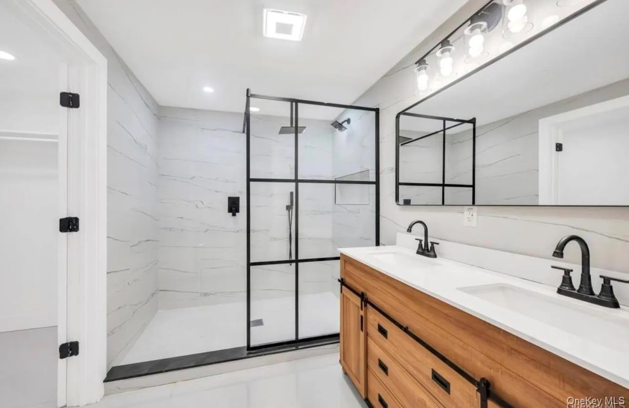 Bathroom with double vanity and a marble finish shower Bathroom with double vanity and a marble finish shower