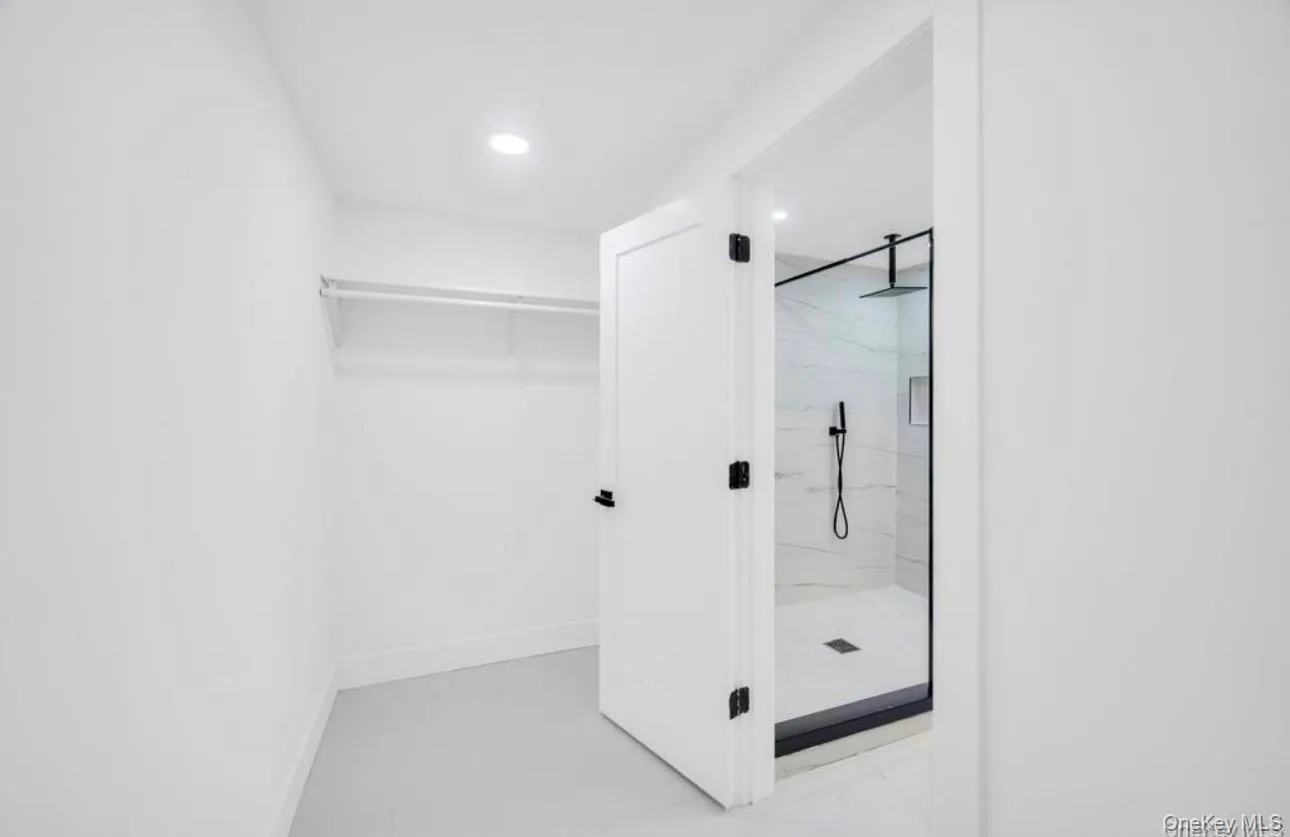 Full bathroom featuring a marble finish shower, a walk in closet, and recessed lighting Full bathroom featuring a marble finish shower, a walk in closet, and recessed lighting