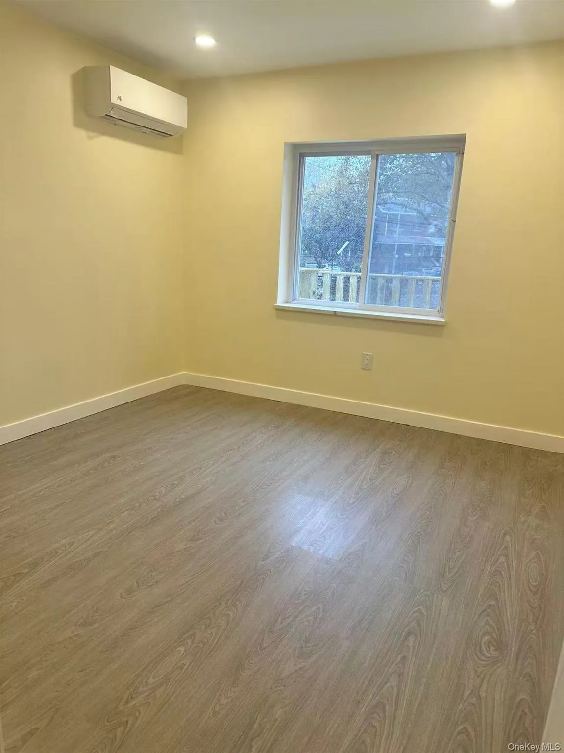 Unfurnished room featuring wood finished floors, an AC wall unit, and recessed lighting Unfurnished room featuring wood finished floors, an AC wall unit, and recessed lighting