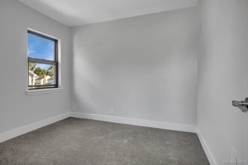 Carpeted empty room featuring baseboards Carpeted empty room featuring baseboards