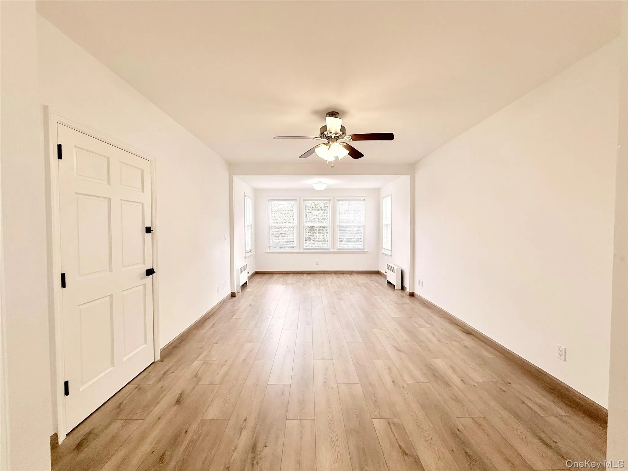 Spare room featuring light wood-style flooring and a ceiling fan Spare room featuring light wood-style flooring and a ceiling fan
