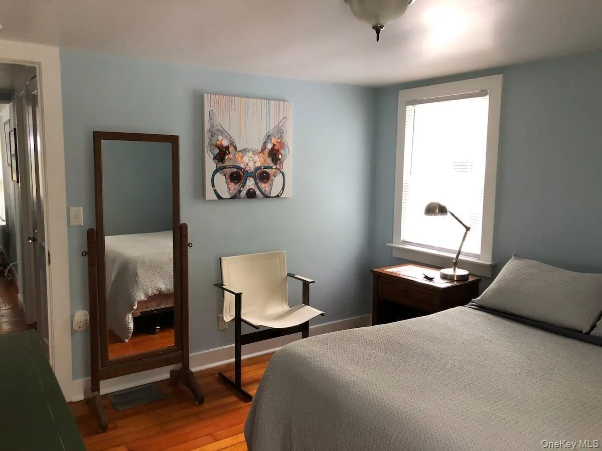 Bedroom featuring hardwood / wood-style floors and baseboards Bedroom featuring hardwood / wood-style floors and baseboards