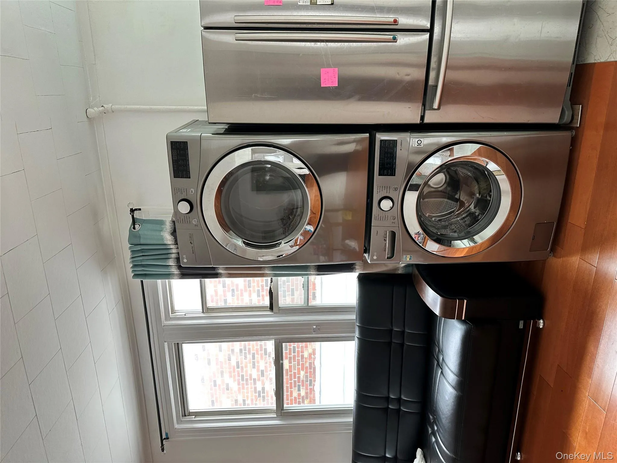 Laundry room with estacked washer and dryer and wood finished floors Laundry room with estacked washer and dryer and wood finished floors