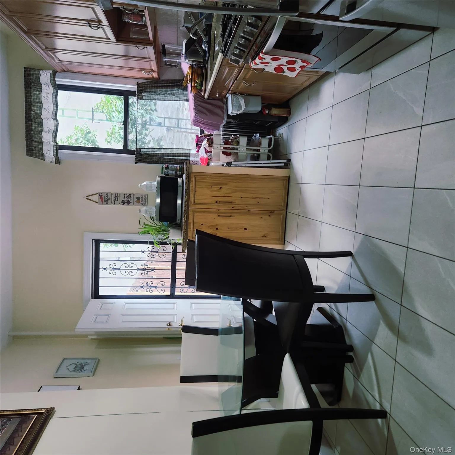 Kitchen featuring plenty of natural light, light tile patterned floors, fridge, and stove Kitchen featuring plenty of natural light, light tile patterned floors, fridge, and stove
