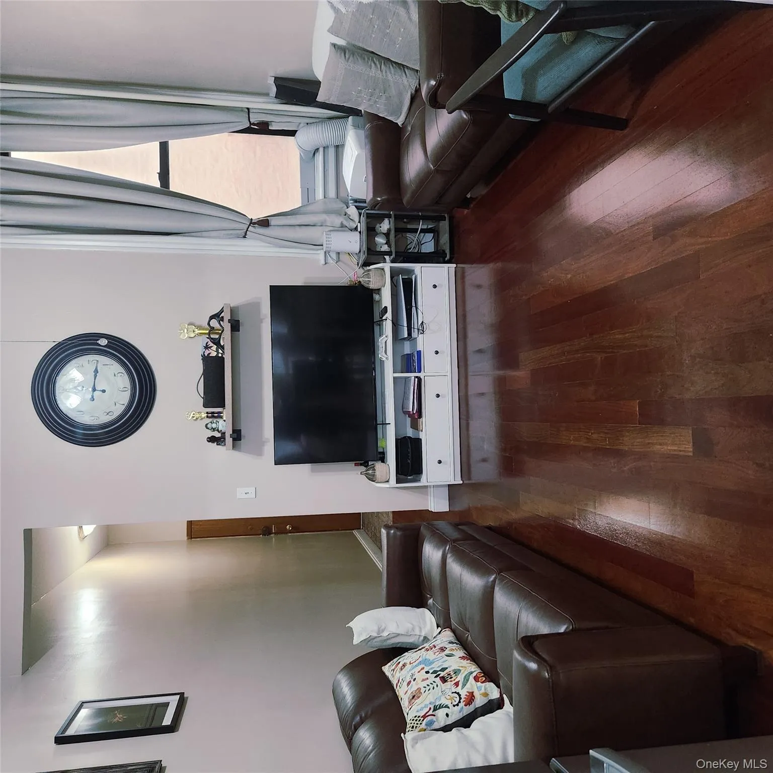 Living room featuring dark wood-style floors and baseboards Living room featuring dark wood-style floors and baseboards