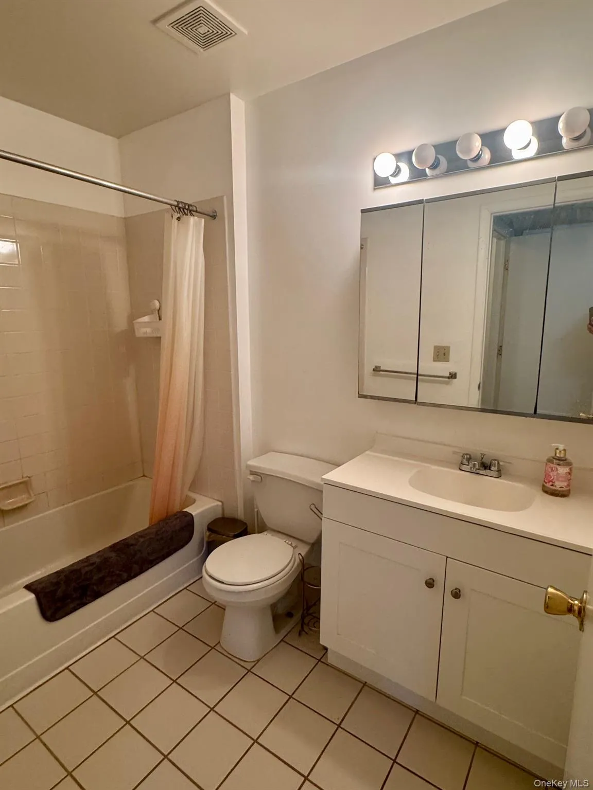 Bathroom with light tile patterned floors, shower / bath combination with curtain, and vanity Bathroom with light tile patterned floors, shower / bath combination with curtain, and vanity