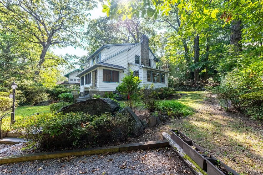 View of property exterior with a chimney and view of scattered trees View of property exterior with a chimney and view of scattered trees