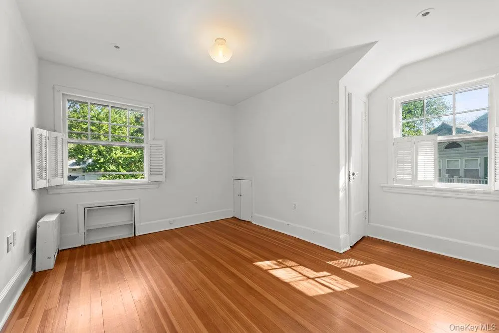 Unfurnished room with baseboards and light wood-style floors Unfurnished room with baseboards and light wood-style floors