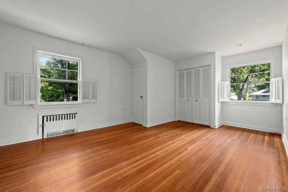 Bonus room featuring radiator heating unit and light wood-style flooring Bonus room featuring radiator heating unit and light wood-style flooring