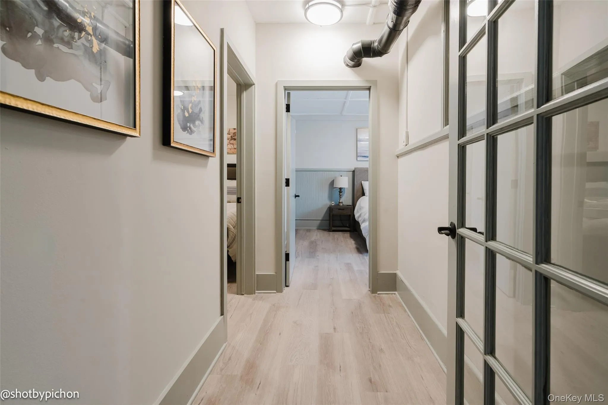 Hall featuring light wood-type flooring and baseboards Hall featuring light wood-type flooring and baseboards