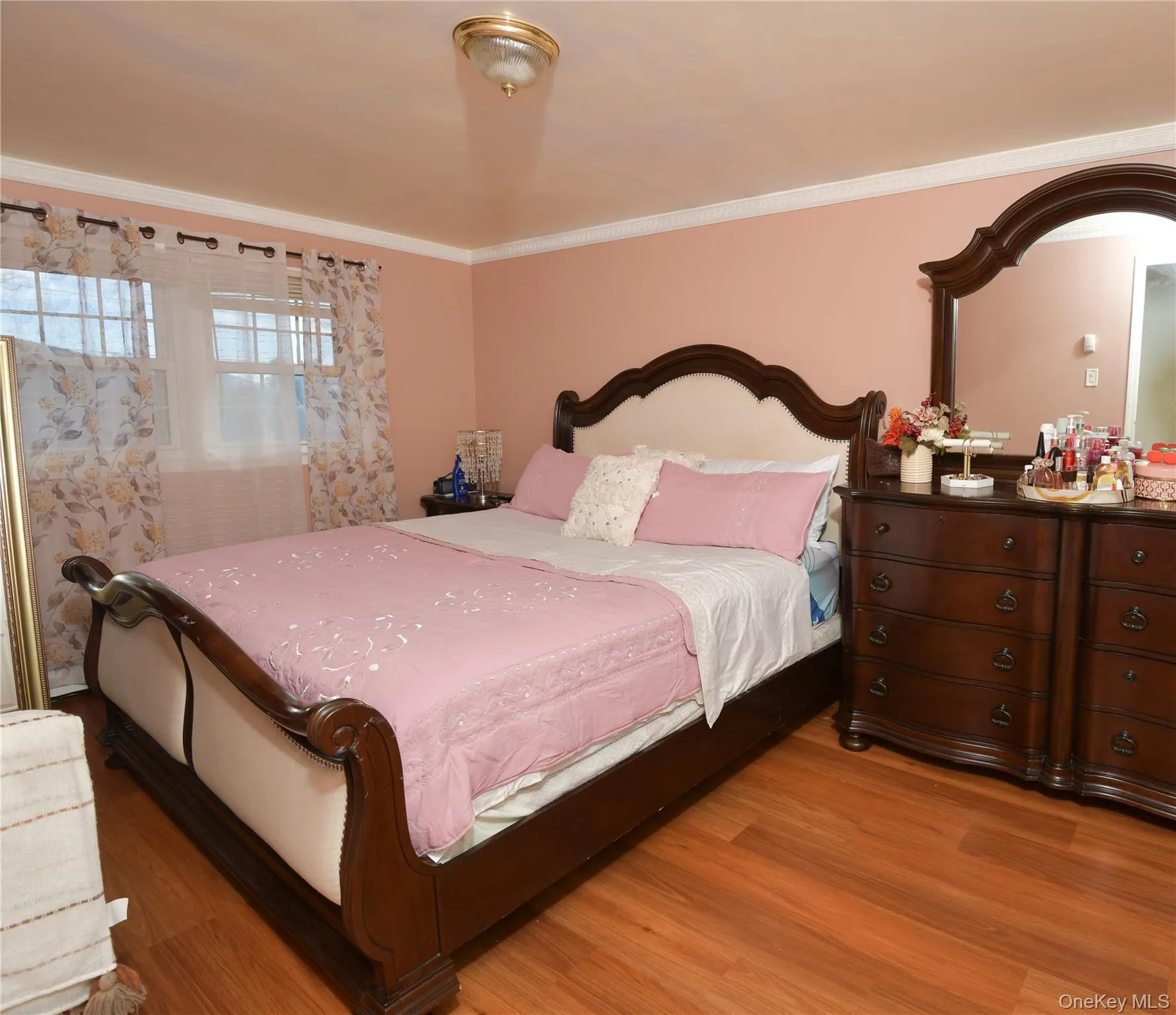 Bedroom with ornamental molding and wood finished floors Bedroom with ornamental molding and wood finished floors