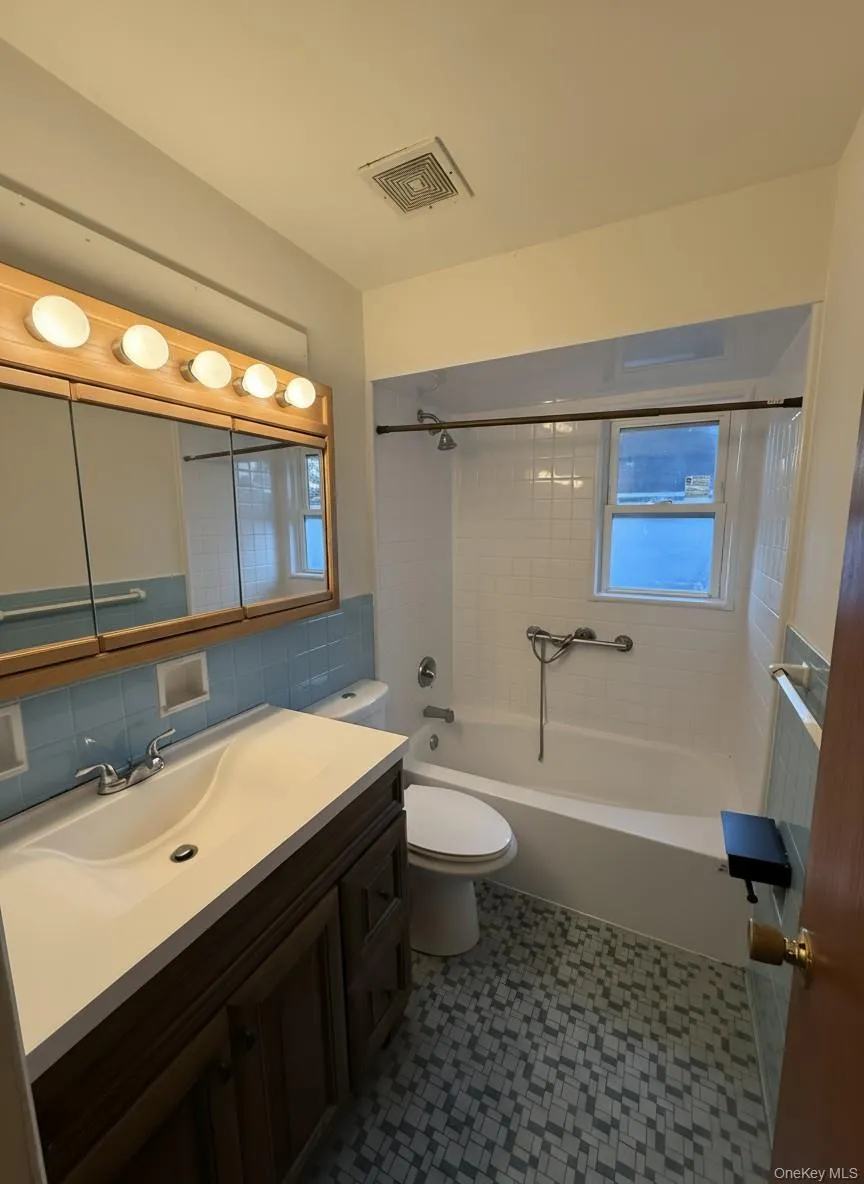 Bathroom with vanity, bathing tub / shower combination, tile walls, and tasteful backsplash Bathroom with vanity, bathing tub / shower combination, tile walls, and tasteful backsplash