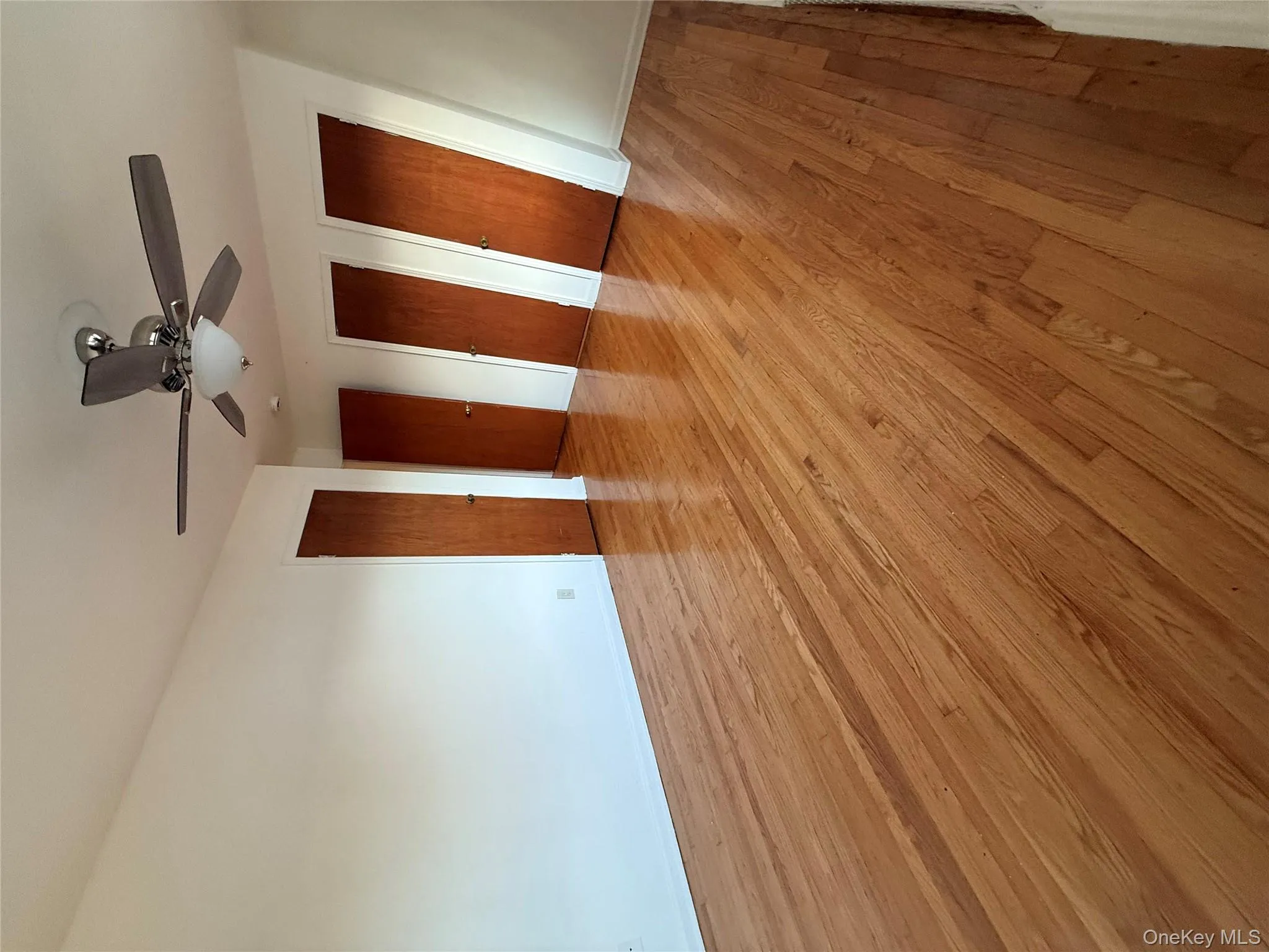 Unfurnished bedroom with two closets, light wood-style flooring, and ceiling fan Unfurnished bedroom with two closets, light wood-style flooring, and ceiling fan