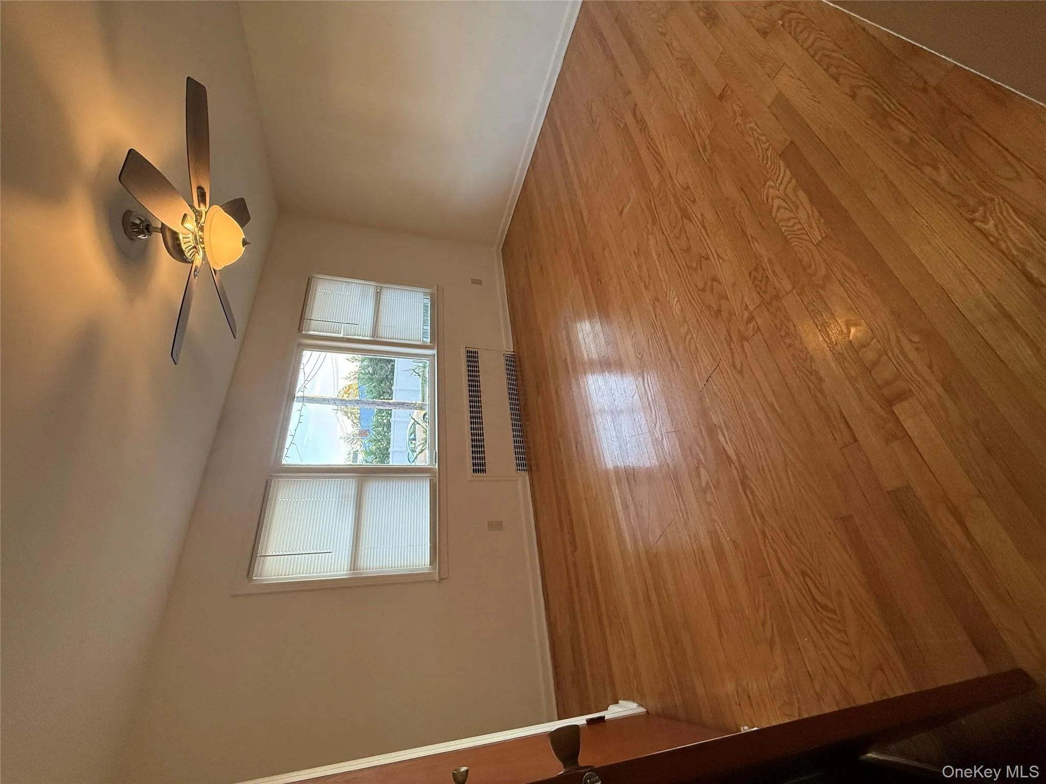 Spare room featuring light wood-style floors, radiator, and ceiling fan Spare room featuring light wood-style floors, radiator, and ceiling fan