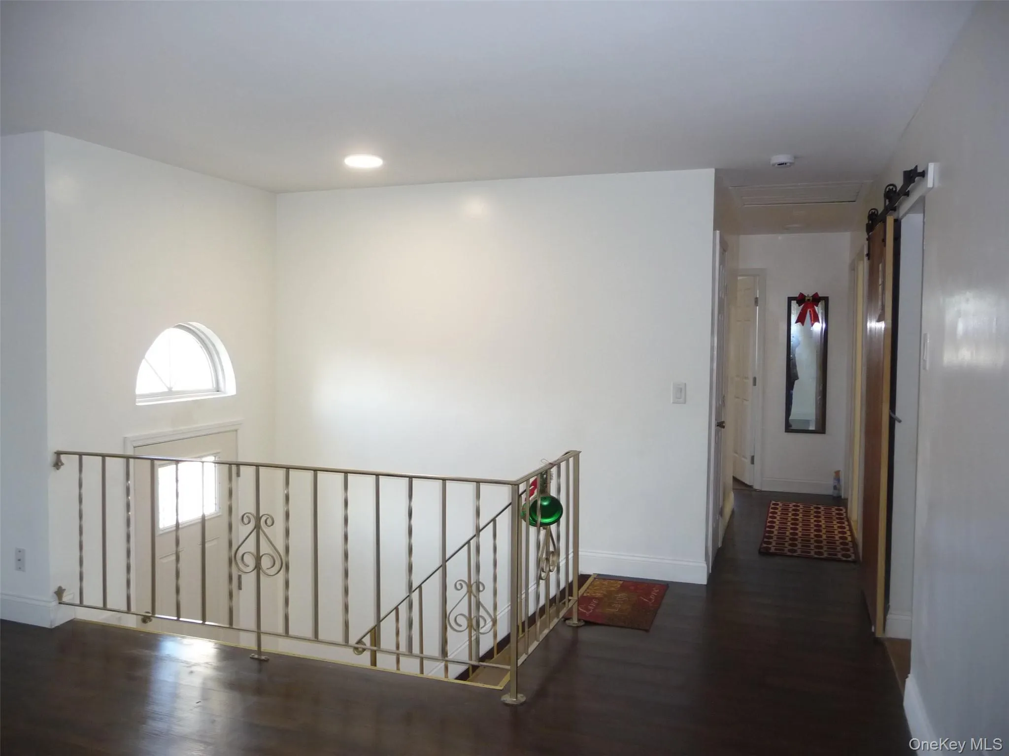 Corridor with a barn door, dark wood finished floors, an upstairs landing, and recessed lighting Corridor with a barn door, dark wood finished floors, an upstairs landing, and recessed lighting