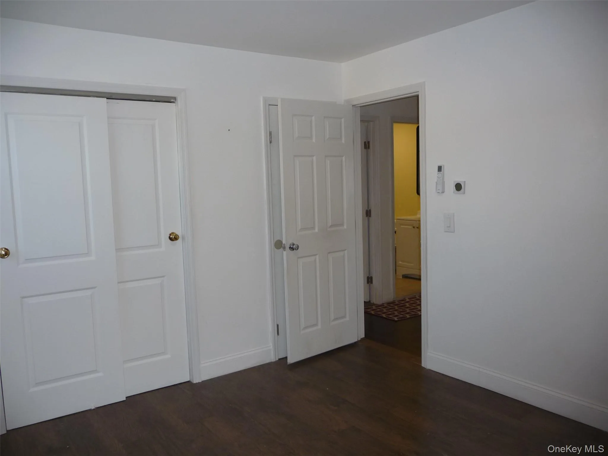 Unfurnished bedroom with a closet and dark wood-type flooring Unfurnished bedroom with a closet and dark wood-type flooring