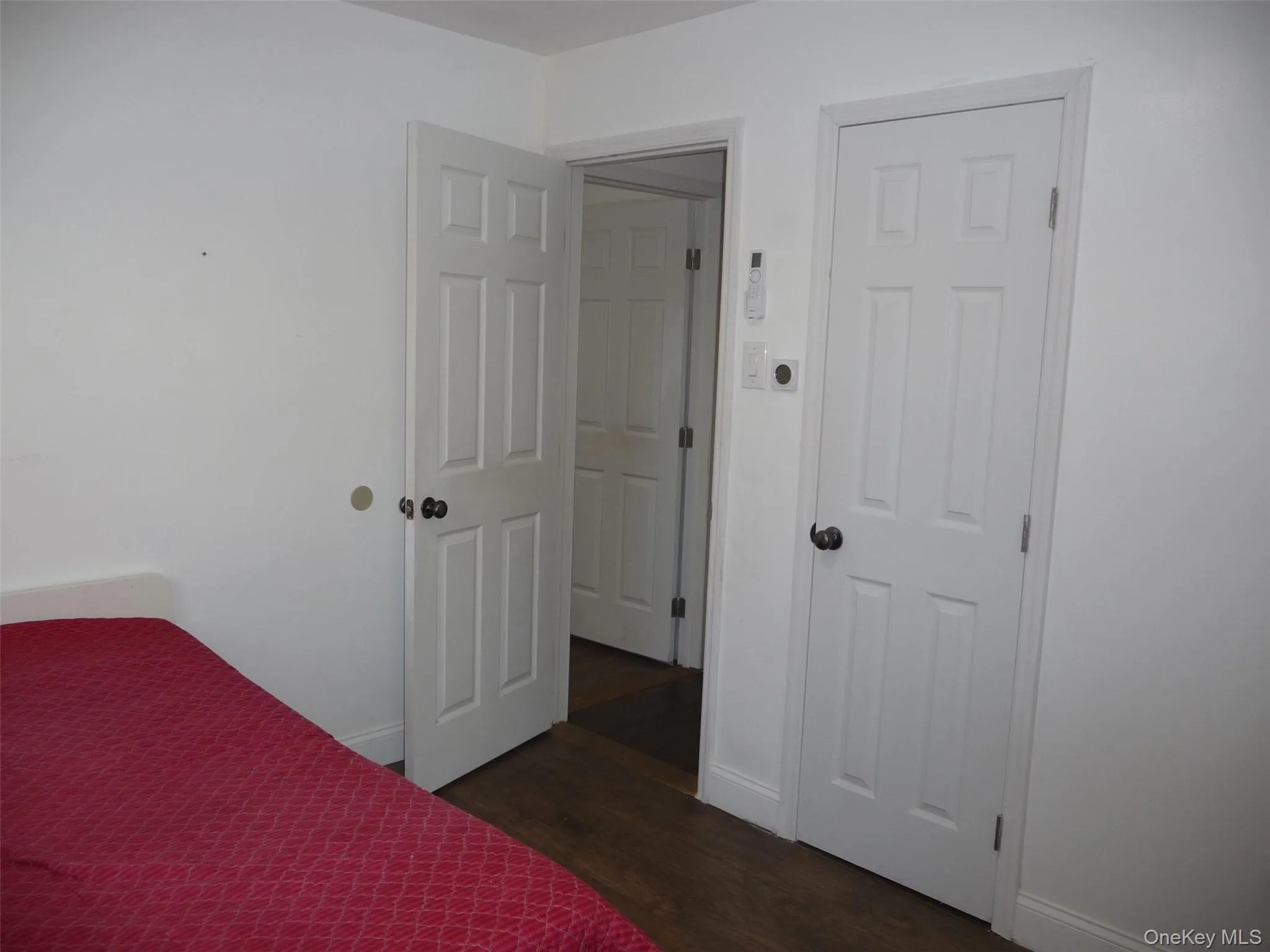 Unfurnished bedroom featuring dark wood finished floors and baseboards Unfurnished bedroom featuring dark wood finished floors and baseboards