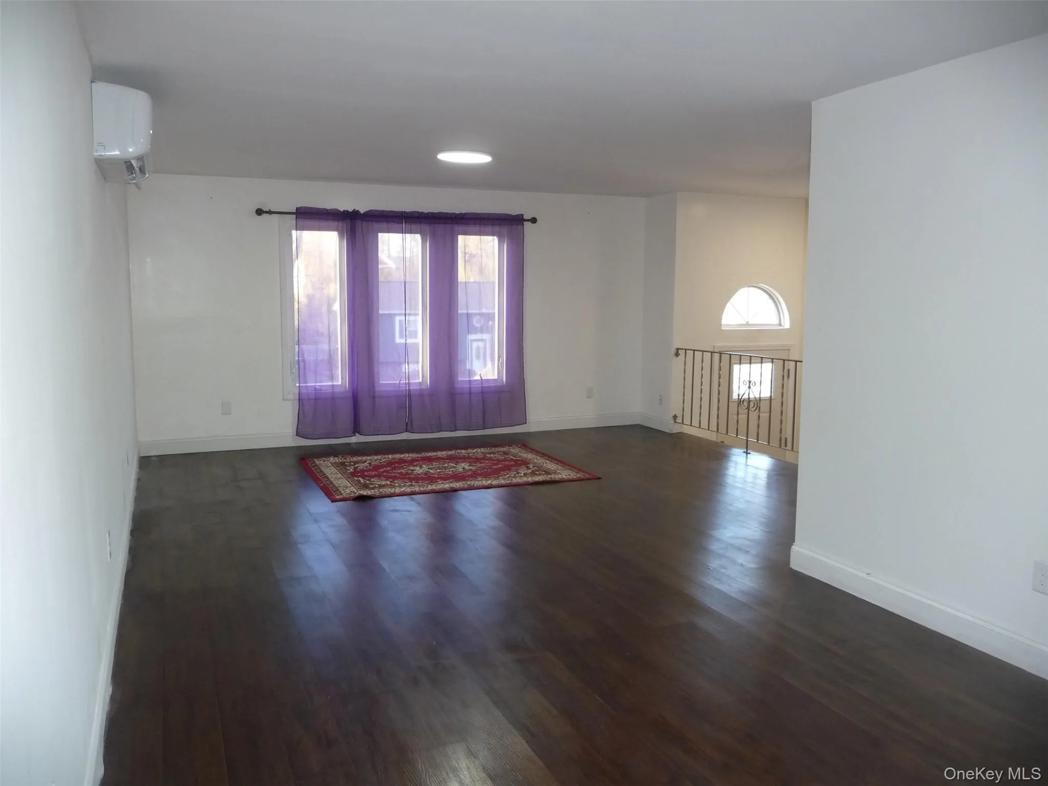 Entrance foyer featuring dark wood-style flooring, an AC wall unit, and recessed lighting Entrance foyer featuring dark wood-style flooring, an AC wall unit, and recessed lighting