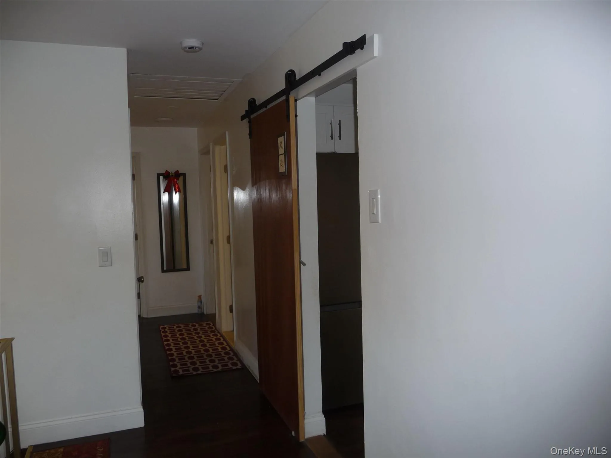 Hall with dark wood finished floors and a barn door Hall with dark wood finished floors and a barn door