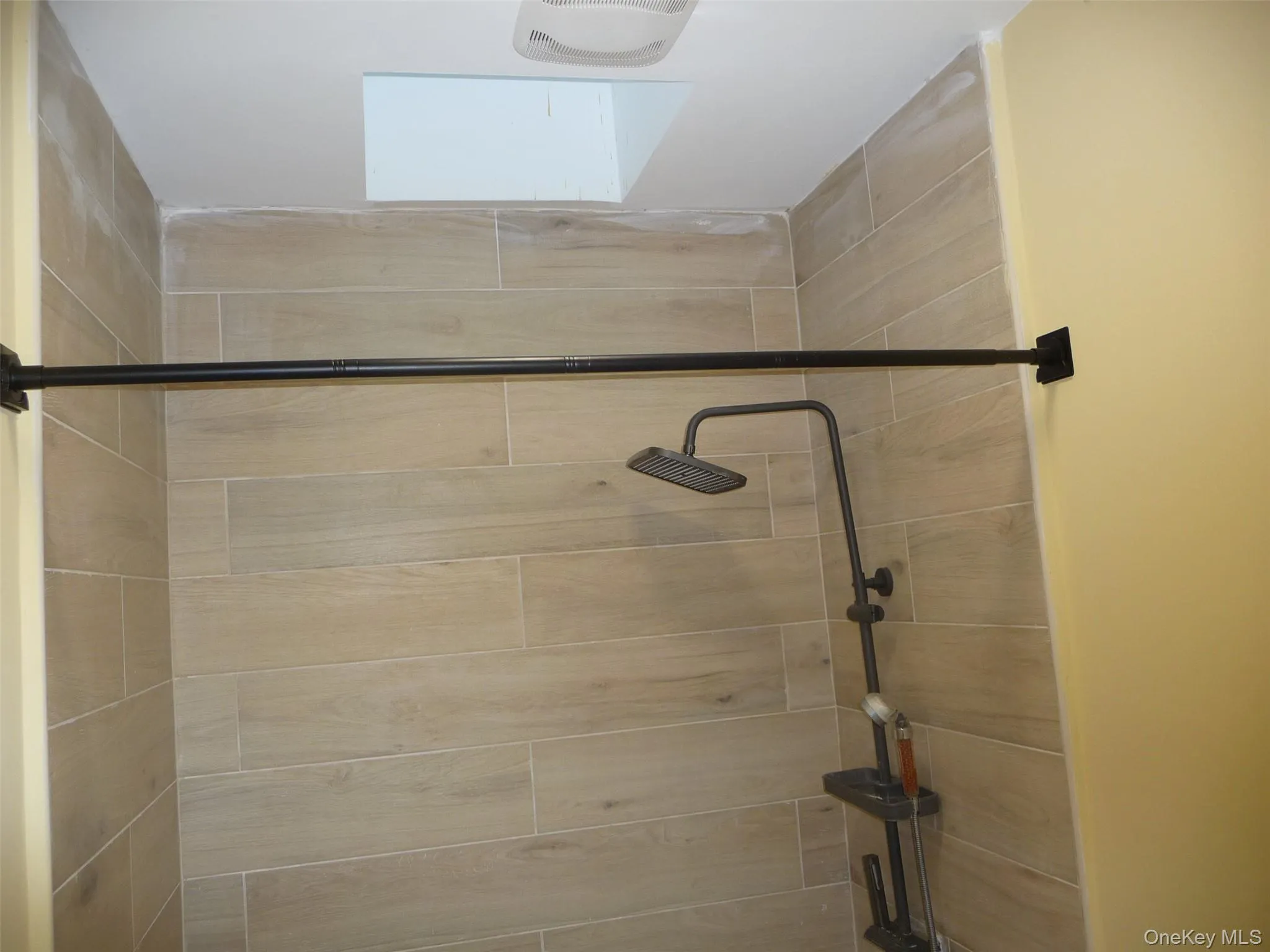 Bathroom featuring a stall shower and a skylight Bathroom featuring a stall shower and a skylight