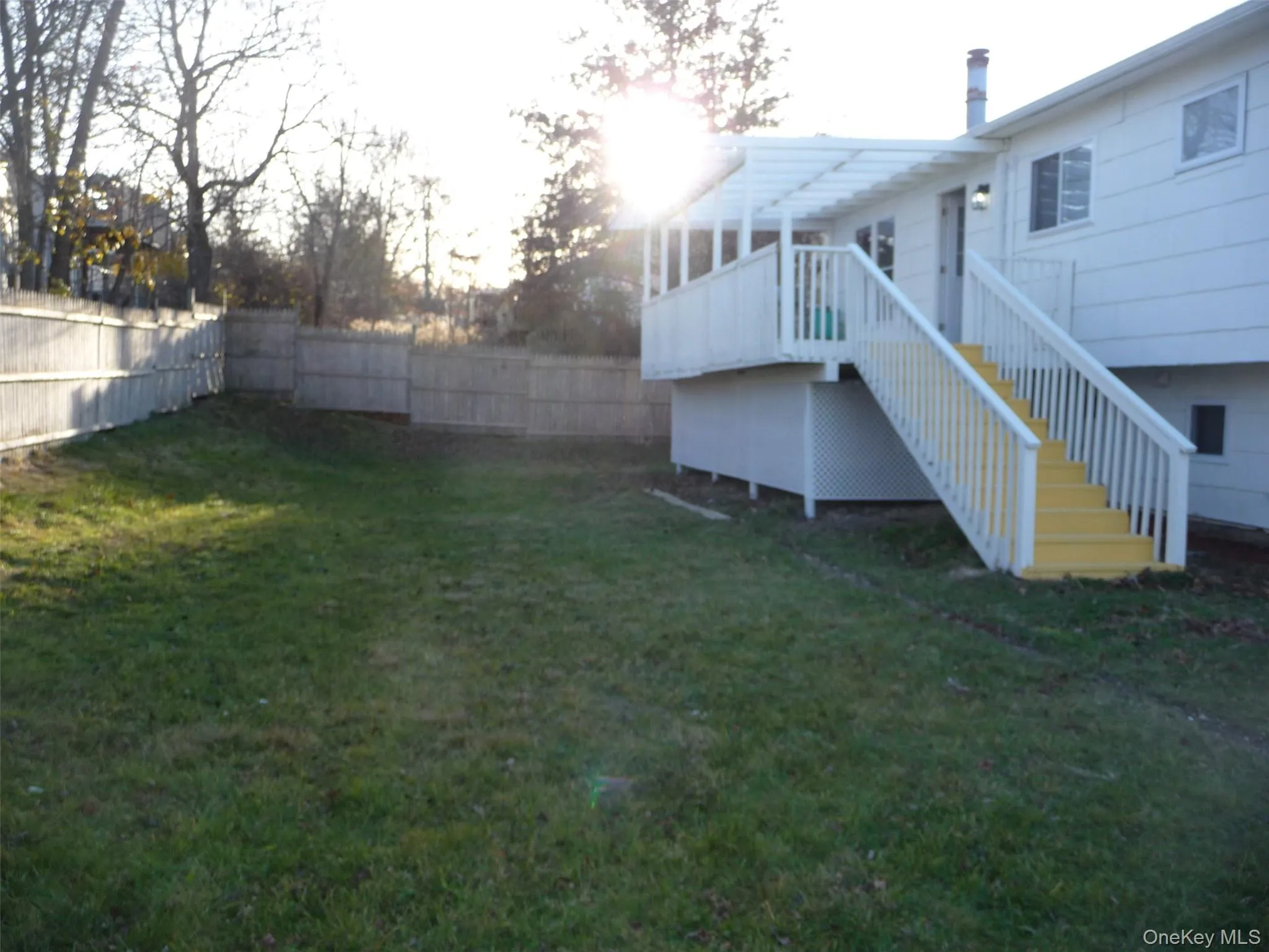 Fenced backyard featuring stairs and a wooden deck Fenced backyard featuring stairs and a wooden deck