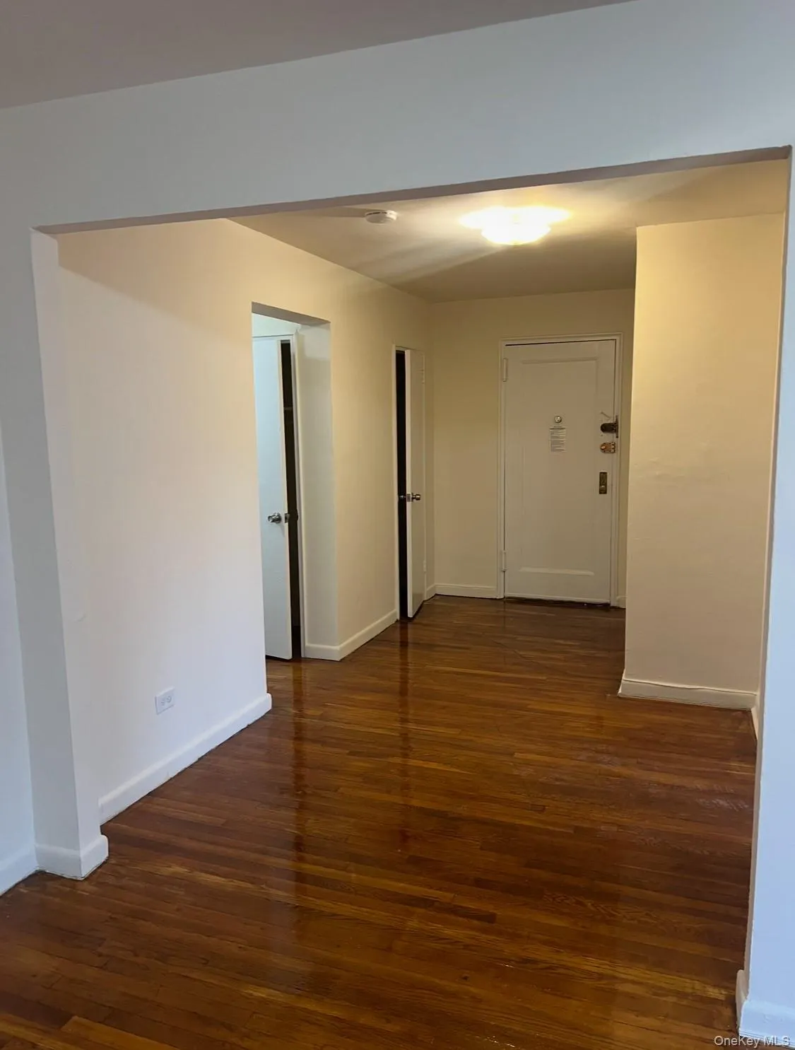 Corridor featuring baseboards and dark wood finished floors Corridor featuring baseboards and dark wood finished floors