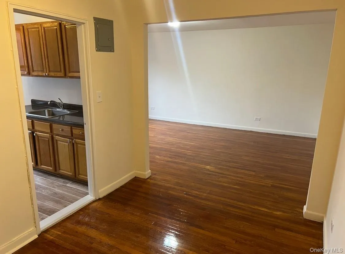 Hall with dark wood-style flooring and electric panel Hall with dark wood-style flooring and electric panel