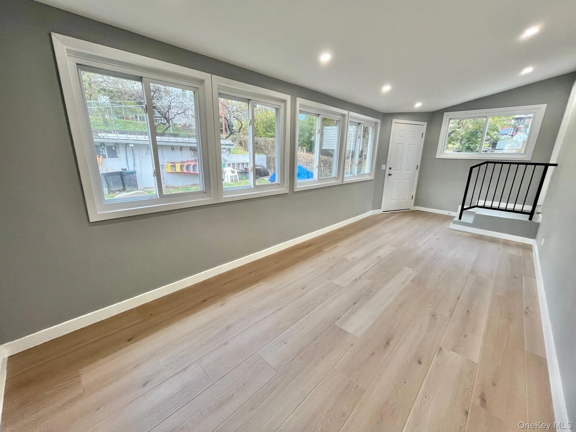 Empty room featuring recessed lighting, light wood-style flooring, and lofted ceiling Empty room featuring recessed lighting, light wood-style flooring, and lofted ceiling