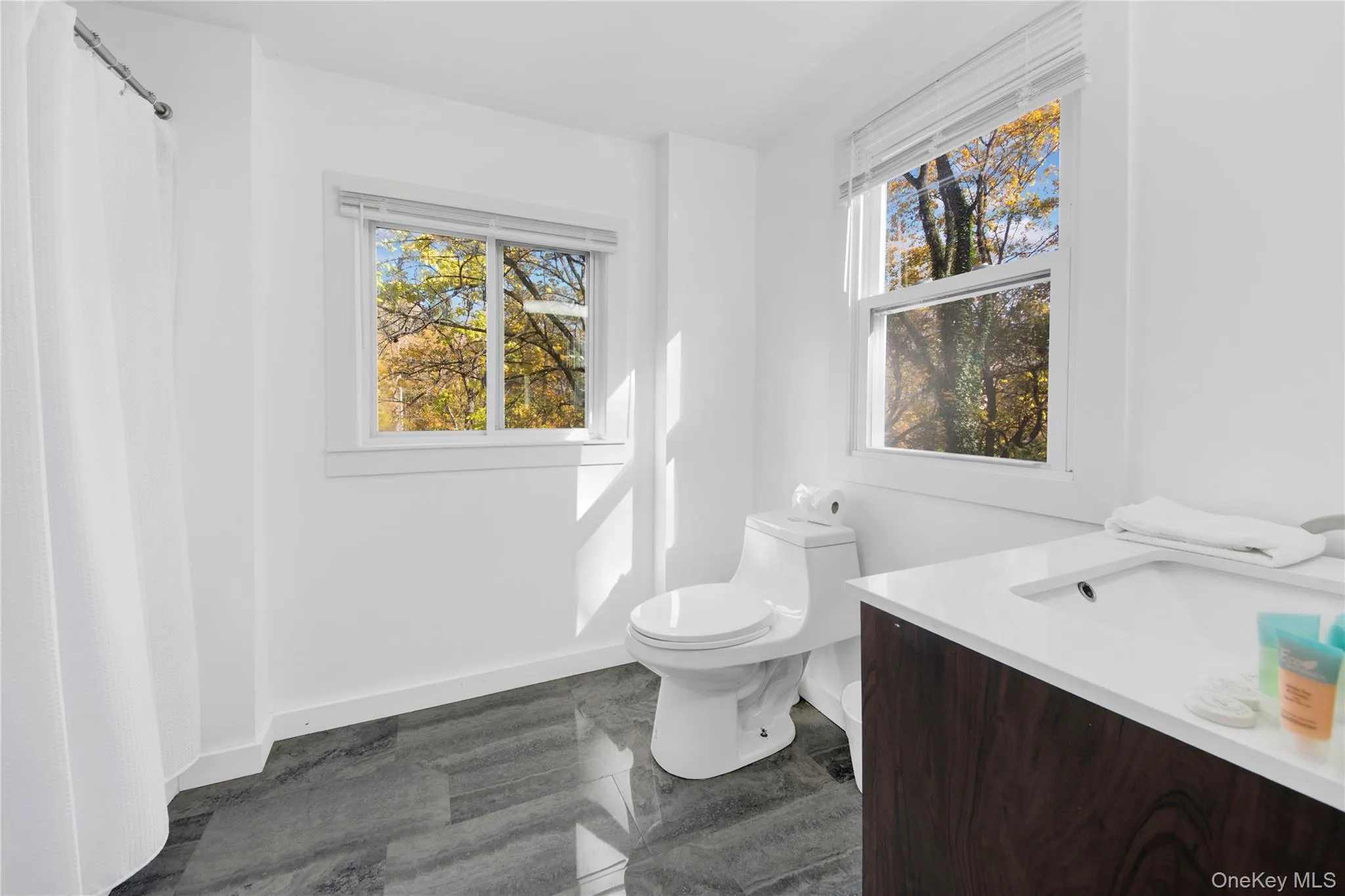 Full bath with vanity, a shower with shower curtain, healthy amount of natural light, and dark wood-type flooring Full bath with vanity, a shower with shower curtain, healthy amount of natural light, and dark wood-type flooring