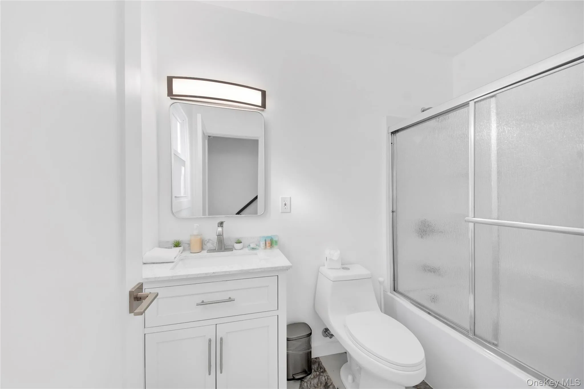 Full bathroom featuring shower / bath combination with glass door and vanity Full bathroom featuring shower / bath combination with glass door and vanity