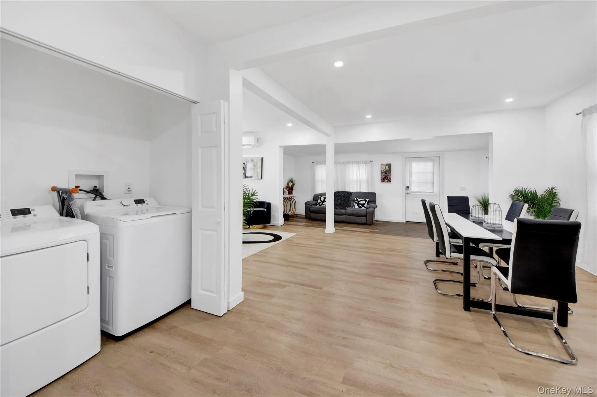 Laundry room with light wood-type flooring, recessed lighting, and separate washer and dryer Laundry room with light wood-type flooring, recessed lighting, and separate washer and dryer