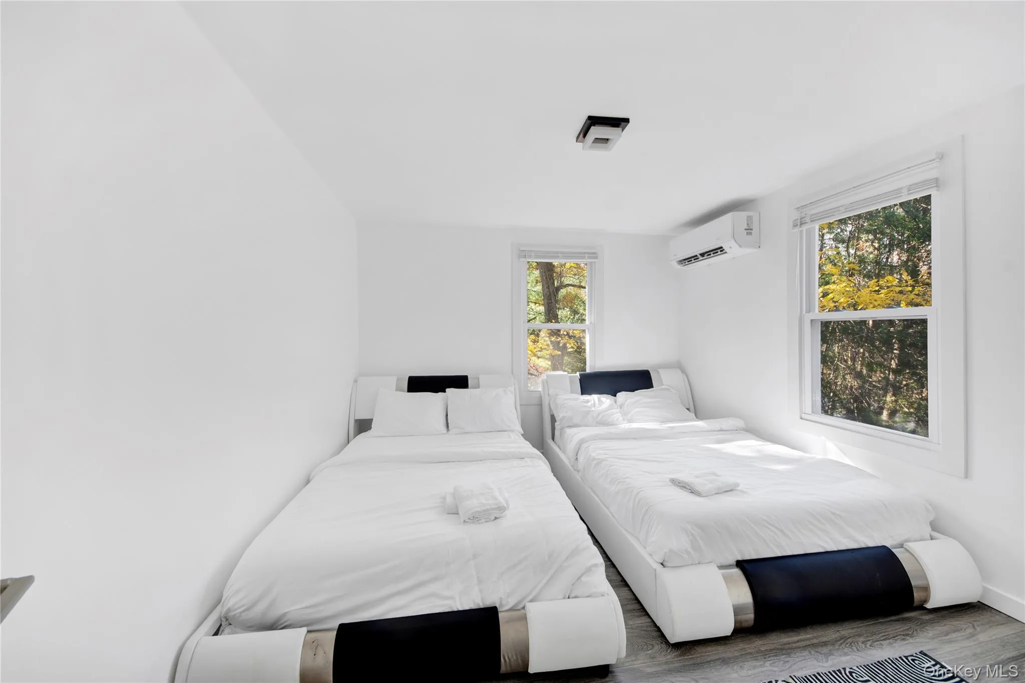 Bedroom featuring wood finished floors and an AC wall unit Bedroom featuring wood finished floors and an AC wall unit