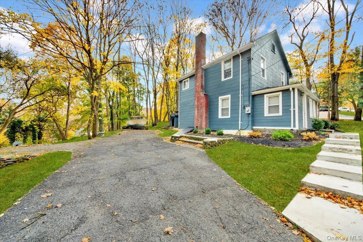 View of front of house featuring a chimney, asphalt driveway, and a front yard View of front of house featuring a chimney, asphalt driveway, and a front yard