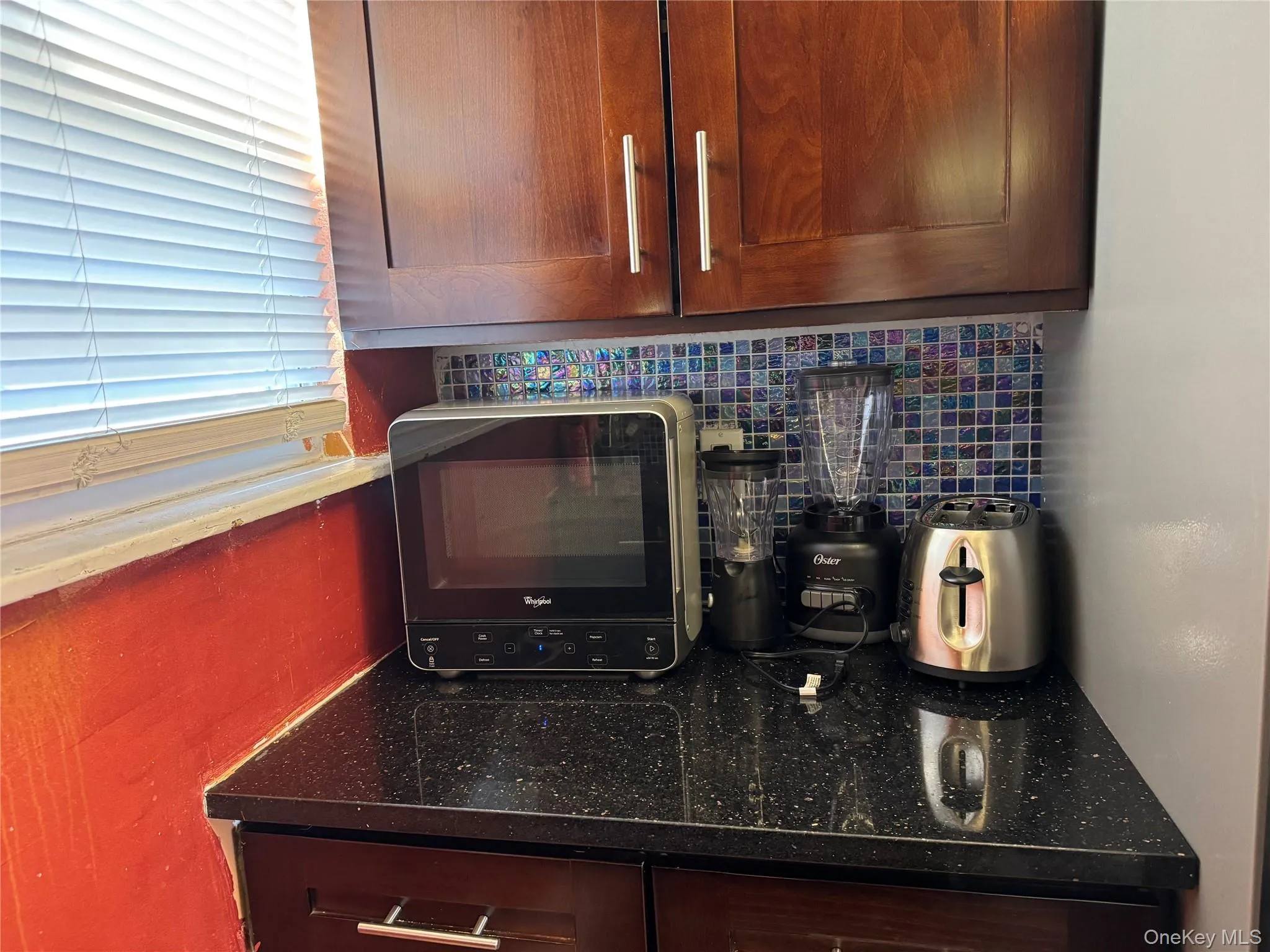Kitchen view of backsplash, and dark stone counters Kitchen view of backsplash, and dark stone counters