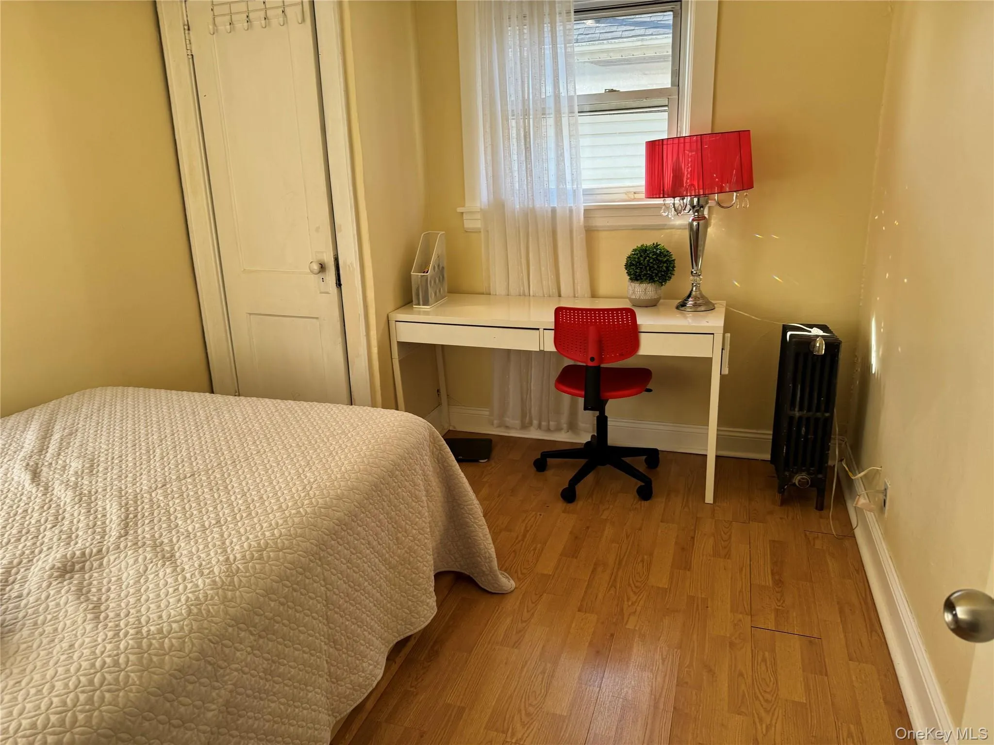 Bedroom with light wood-style floors, and an office area Bedroom with light wood-style floors, and an office area